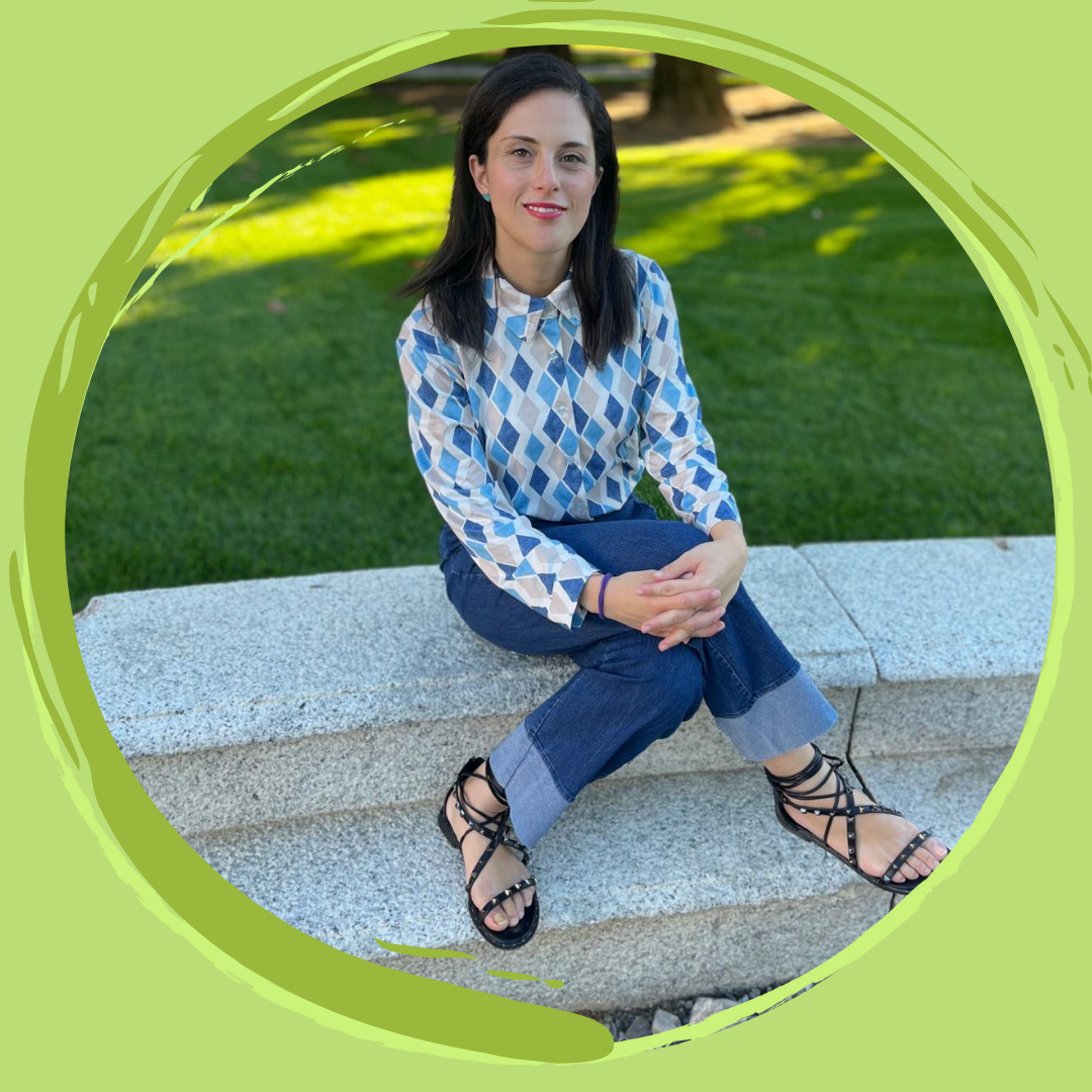 La copy sostenibile-contatti. È Azzurra Papalia, una seo copywriter che si occupa di storytelling di sostenibilità. È seduta in un anfiteatro circondato da un grande giardino dai colori autunnali.