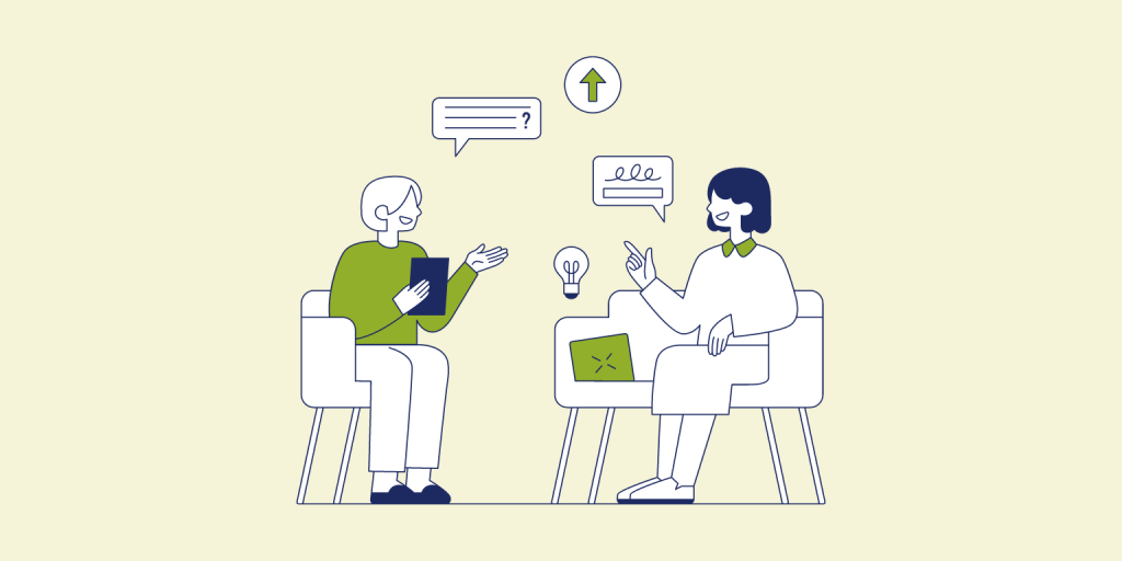 Due ragazze sedute in un salottino conversano e si scambiano idee sui contenuti e l'utilità della seo ecologica. Ognuna delle due è seduta su una poltrona bianca diversa, poste una davanti all'altra. A destra c'è una ragazza dai capelli blu e un vestito bianco che sorride alla ragazza di fronte che ha un caschetto bianco e indossa una blusa verde e un pantalone bianco.